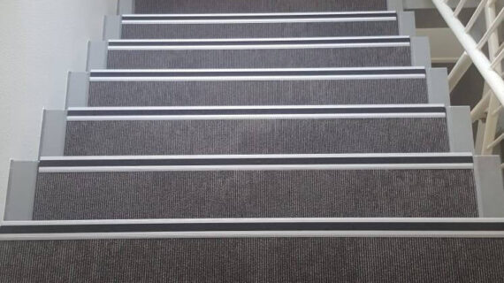 gestoffeerde trap in trappenhuis donker tapijt
