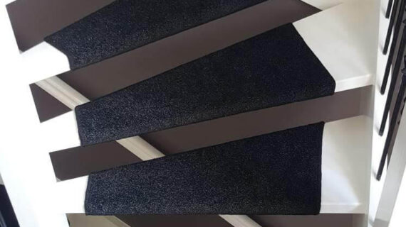 Open trap met zwart tapijt rondom gestoffeerd